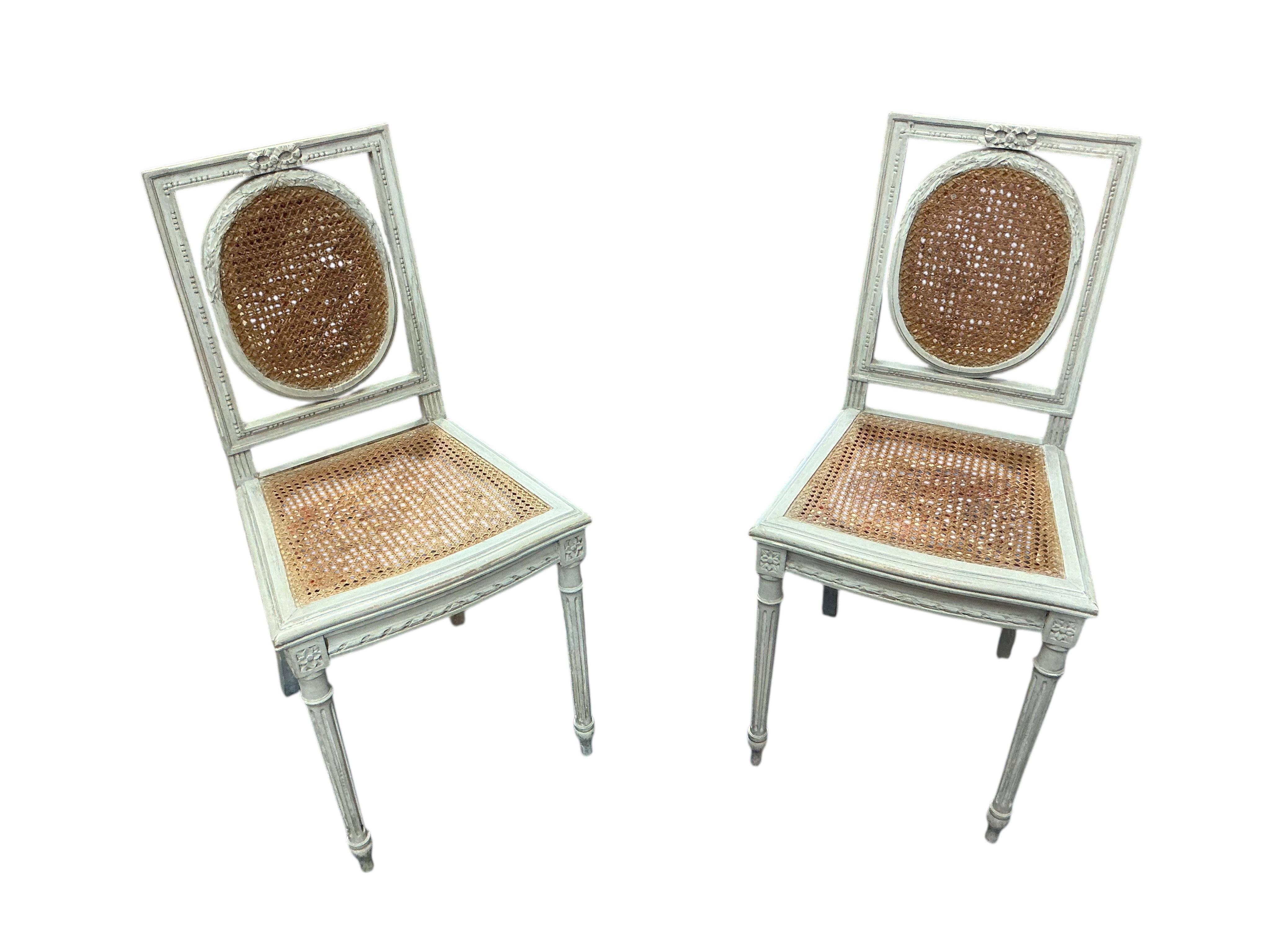 A pair of early 20th century French painted caned side chairs and one other chair